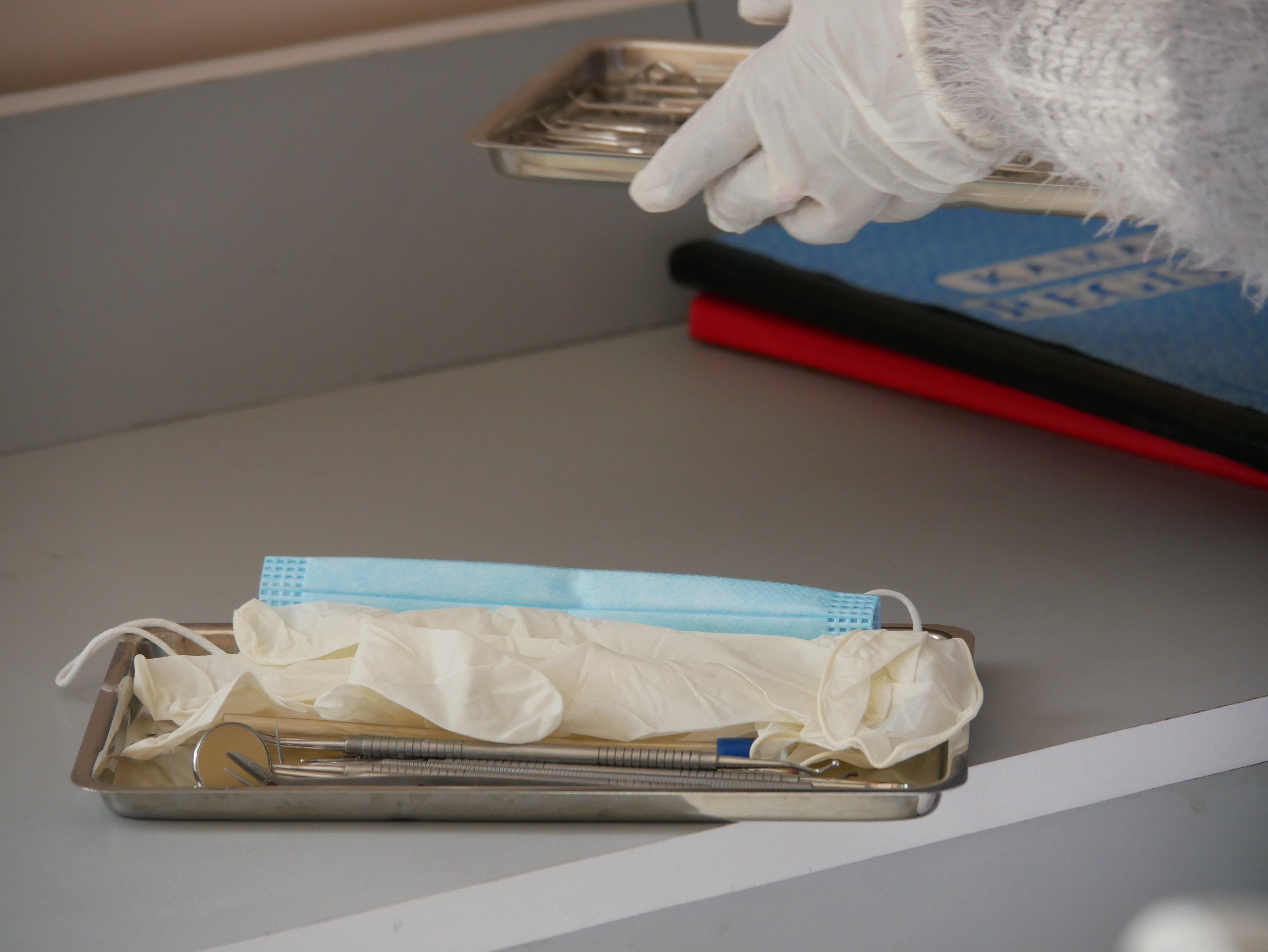 a tray with a mask, gloves and dental care tools