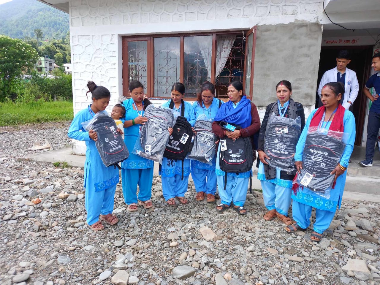 Seven women each holding a brand-new backpack.